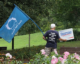 Nikos Frazier | The Vindicator..Werner Lange of Newton Falls holds a "Bernie for President" sign and "Feel the Bern" flag outside the Kilcawley Center at Youngstown State University before Donald J. Trump introduced his foreign policy Monday.