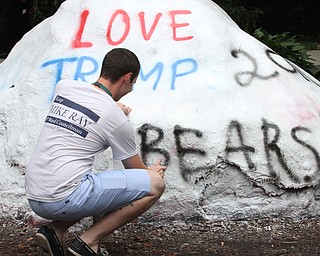 Nikos Frazier | The Vindicator..Jake Schriner-Briggs paints over "Go Bears" outside the Kilcawley Center on Monday. Schriner-Briggs and other students painted "Love Trumps Hate" on the Rock Sunday night but an unkown party painted over "ate" and was replaced with "Go Bears."