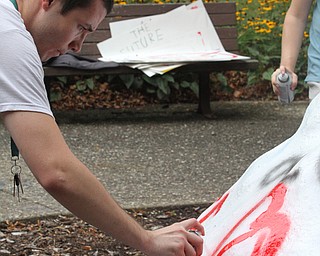 Nikos Frazier | The Vindicator..Jake Schriner-Briggs paints a heart on the Rock outside the Kilcawley Center on Monday.