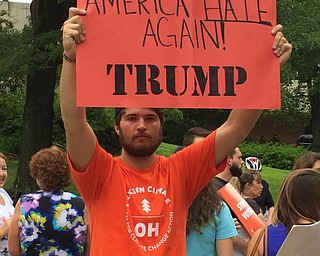 Robert McFerren | The Vindicator..Steven Brown, a YSU senior, holds his protest sign during the Trump speech at YSU.