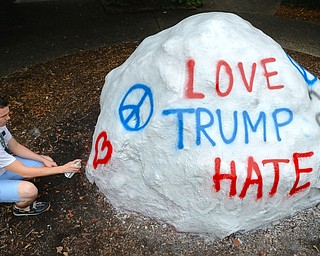 Jeff Lange | The Vindicator  MON, AUG 15, 2016 - Jacob Schriner-Briggs of YSU's College Democrats paints over YSU's rock that once read "Love Trump" prior to the start of Donald Trump's event at the Kilcawley Center, Monday morning.