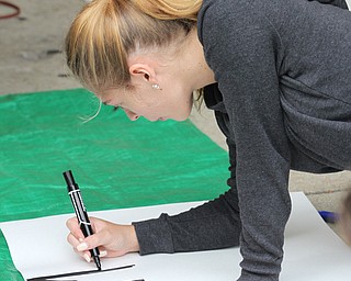 Nikos Frazier | The Vindicator..Katie Morrison, a junior at YSU, begins to write "No Hum[an]" sign outside the Kilcawley Center at the Youngstown State University.