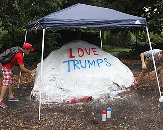 Nikos Frazier | The Vindicator..Jake Schriner-Briggs and Bruno Serano use white spray paint to cover the previous artists work on the Youngstown State Rock.