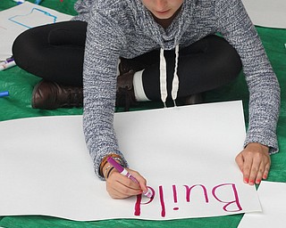 Nikos Frazier | The Vindicator..Melissa Dahman, 16 of Canfield, writes on a fresh sign outside the Kilcawley Center at the Youngstown State University.