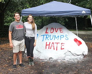 Nikos Frazier | The Vindicator..Kelly Dahman and Joe Sebest pose next to the freshly painted rock at Youngstown State University.