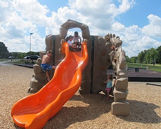 Neighbors | Alexis Bartolomucci.Children at the Walter Terlecky playground at Austintown Township Park climbed the rock wall and slid down the slide.