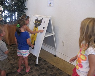 Neighbors | Alexis Bartolomucci.Children lined up to play with the Pete the Cat button activity at the Austintown library on July 27 during the Pete the Cat event.
