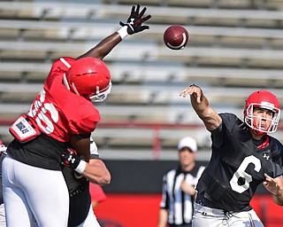 YOUNGSTOWN, OHIO - AUGUST 20, 2016: Hunter Wells #6 (black) throws a pass from he pocket while avoiding the outstretched arm of Christiaan Randall-Posey #36 (red) during a scrimmage Saturday morning at Stambaugh Stadium. DAVID DERMER | THE VINDICATOR