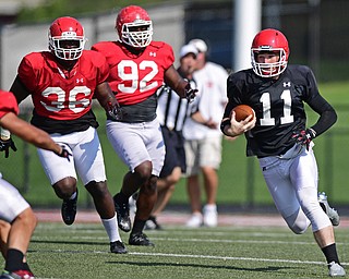 YOUNGSTOWN, OHIO - AUGUST 20, 2016: Trent Hostic #11(black) runs with the football away from defenders after breaking into the open field during a scrimmage Saturday morning at Stambaugh Stadium. DAVID DERMER | THE VINDICATOR