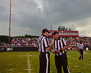 STRUTHERS, OHIO - AUGUST 25, 2016: The referees have a discussion on the field at the start of a weather delay with 29 seconds left in the first quarter. DAVID DERMER | THE VINDICATOR