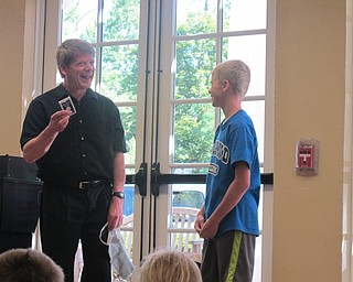 Neighbors | Alexis Bartolomucci.One of the audience members volunteered to help magician, Jeff Wawrzaszek, with one of his invisible card tricks at the Poland library magic show on August 3.