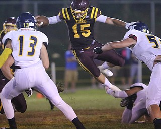  .          ROBERT  K. YOSAY | THE VINDICATOR..South Range #15 Seth Morrow  leaps over McDonald players to get a first down  during third quarter action -   #13 McDonald is Dylan Portolese - and #51  i Hunter Kutch..McDonald at South Range in North Lima..-30-