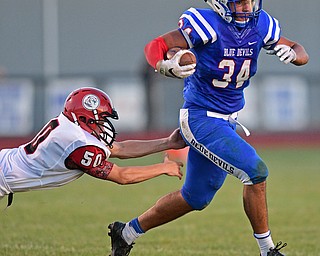 BERLIN CENTER, OHIO - AUGUST 26, 2016: Running back Jack Cappabianca #34 of Western Reserve slips out of a arm tackle from Zach Witherow #50 of Columbiana before breaking into the open for big yardage in the first half of their game Friday night at Western Reserve High School. DAVID DERMER | THE VINDICATOR