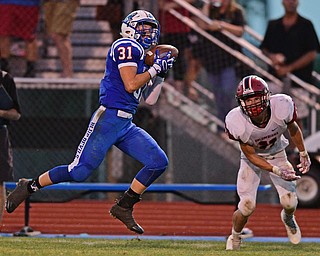 BERLIN CENTER, OHIO - AUGUST 26, 2016: Adam Gatrell #31 of Western Reserve catches the football in stride and away from Tanner Pearl #11 of Columbiana before running into the end zone to score a touchdown in the first half of their game Friday night at Western Reserve High School. DAVID DERMER | THE VINDICATOR