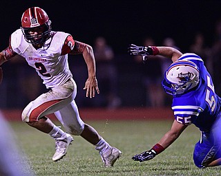 BERLIN CENTER, OHIO - AUGUST 26, 2016: Quarterback Mitch Davidson #2 of Columbiana slips away from Matt Henry #55 of Western Reserve allowing him to throw a touchdown pass in the second half of their game Friday night at Western Reserve High School. DAVID DERMER | THE VINDICATOR