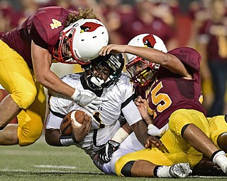YOUNGSTOWN, OHIO - AUGUST 27, 2016: Reggie Harris #1 of Cleveland Heights is brought down hard by Alex Sepesy #4 and Antonio Page #15 of Mooney during the first half of their game Saturday night at Stambaugh Stadium. DAVID DERMER | THE VINDICATOR
