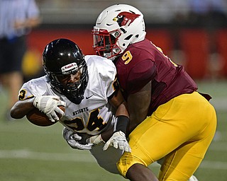 YOUNGSTOWN, OHIO - AUGUST 27, 2016: Xavier Pillar #24 of Cleveland Heights attempts to dive while being tackled by Jaylen Hewlett #9 of Mooney during the first half of their game Saturday night at Stambaugh Stadium. DAVID DERMER | THE VINDICATOR