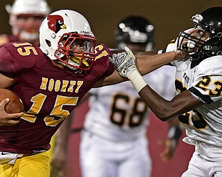 YOUNGSTOWN, OHIO - AUGUST 27, 2016: Antonio Page #15 of Mooney stiff arms Shakorie Davis #23 of Cleveland Heights allowing him to gain more yardage during the first half of their game Saturday night at Stambaugh Stadium. DAVID DERMER | THE VINDICATOR