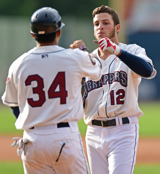 NILES, OHIO - AUGUST 28, 2016: Alexis Pantoja #12 of the Scrappers is congratulated by first base coach Jorma Rodriguez #34 after a hitting a two run single in the sixth inning of Sunday afternoons game at Eastwood Field. DAVID DERMER | THE VINDICATOR