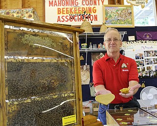        ROBERT K. YOSAY  | THE VINDICATOR..Bruce Zimmer President of the Columbiana Mahoning Bee Keepers shows the bees wax  items for sale.. ... - -30-...