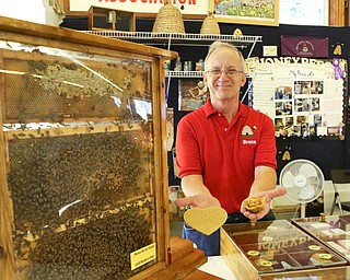        ROBERT K. YOSAY  | THE VINDICATOR..Bruce Zimmer President of the Columbiana Mahoning Bee Keepers shows the bees wax  items for sale.. ... - -30-...