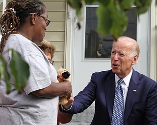 Nikos Frazier | The Vindicator..Vice President Joe Biden hands a stuffed replica of his dog, Champ, to a Youngstown resident while visiting the Idora neighborhood on Thursday, Sept. 1, 2016.