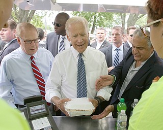        ROBERT K. YOSAY  | THE VINDICATOR..Joe Biden orders a cavatelli  bowl with extra cheese as Ted Strickland and  Dave Betras look on..Biden visits Canfield Fair... - -30-...