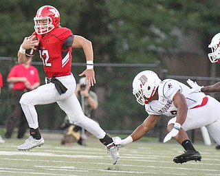 William D. Lewis/The Vindicator YSU QB Ricky Davis(12) scrambles fro 1rst qtr yardage during Sept. 1, 2016 game with Duquesne. Joshua Gills(8) of Duquesne pursues.