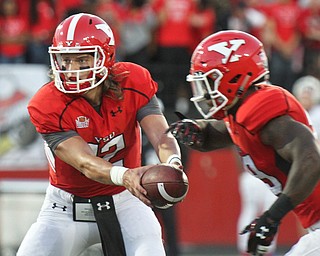 William D. Lewis/The Vindicator YSU QB Ricky Davis (12) hands off to Martin Ruiz(29) during 1rst qtr of Sept. 1, 2016 game with Duquesne