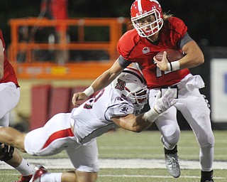William D. Lewis/The Vindicator YSU QB Ricky Davis (12) is stopped by Duquesne's Stephan Osong(40.) during 1rst qtr of Sept. 1, 2016 game with Duquesne