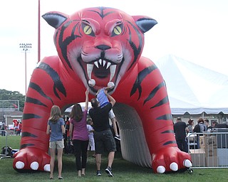 Nikos Frazier | The Vindicator..A man attempts to stick his daughters head into the mouth of the Wildcat while walking into the tailgate party celebrating the 100-year anniversary of the Struthers football program.