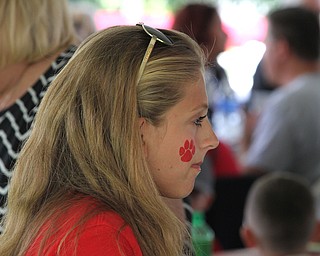Nikos Frazier | The Vindicator..Maddie Bova, 15, talks with her family with a wildcat paw-print on her cheek at the tailgate party celebrating the 100-year anniversary of the Struthers football program.