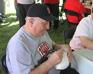 Nikos Frazier | The Vindicator..Joe Martin, Struthers High School class of 1959, signs a commemorative football at the tailgate party celebrating the 100-year anniversary of the Struthers football program.