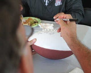 Nikos Frazier | The Vindicator..Dan Flora, Struthers High School class of 1978, signs a commemorative football at the tailgate party celebrating the 100-year anniversary of the Struthers football program.
