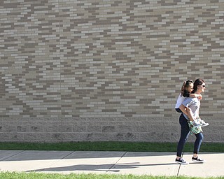 Nikos Frazier | The Vindicator..Marlo DeChellis carries Hailey Carcelli, 6, at Struthers High School.