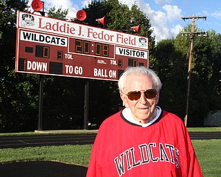 Nikos Frazier | The Vindicator..Laddie Fedor, 92, poses infront of the Laddie J. Fedor Field scoreboard at Struthers High School.