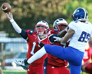 William D. Lewis/The Vindicator Niles Tyler Srbinovich(13) throws as Poland's Nick Miller(85) is blocked by Nick Jarvis(52 ) during Friday Sept. 2, 2016 game at Niles.