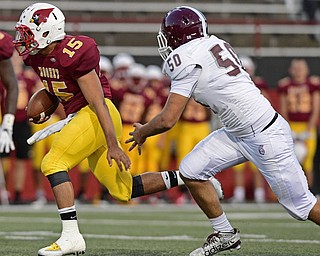YOUNGSTOWN, OHIO - SEPTEMBER 2, 2016: Quarterback Antonio Page #15 of Mooney runs the football away from Steven Amstutz #50 of Boardman during the first half of their game Friday night at Stambugh Stadium. DAVID DERMER | THE VINDICATOR