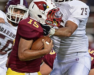 YOUNGSTOWN, OHIO - SEPTEMBER 2, 2016: Quarterback Antonio Page #15 of Mooney runs with the football before breaking out of the arm tackle of Jordan Acevedo #75 of Boardman, and throwing a touchdown pass during the first half of their game Friday night at Stambugh Stadium. DAVID DERMER | THE VINDICATOR