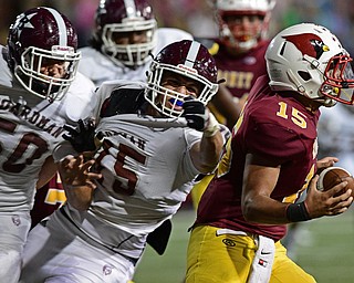 YOUNGSTOWN, OHIO - SEPTEMBER 2, 2016: Quarterback Antonio Page #15 of Mooney runs away from Steven Amstutz #50 and Jordan Acevedo #75 of Boardman during the first half of their game Friday night at Stambugh Stadium. DAVID DERMER | THE VINDICATOR