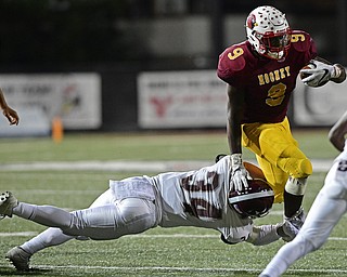 YOUNGSTOWN, OHIO - SEPTEMBER 2, 2016: Running back Jaylen Hewlett #9 of Mooney stiff arms Gaven Strines #34 of Boardman allowing for extra yardage during the second half of their game Friday night at Stambaugh Stadium. DAVID DERMER | THE VINDICATOR