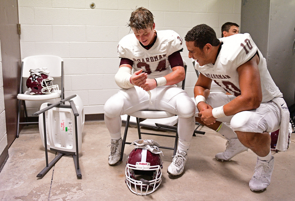 YOUNGSTOWN, OHIO - SEPTEMBER 2, 2016: Gaven Strines #34 (left) and Travis Koontz #10 of Boardman smile in the locker room following their 28-26 victory over Cardinal Mooney at Stambaugh Stadium. DAVID DERMER | THE VINDICATOR