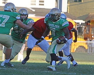Ursuline's Joe Floyd (7) picks up a block from teammate Dan Henry (57) during the first quarter of Friday nights matchup at Rayen Field in Youngstown.
