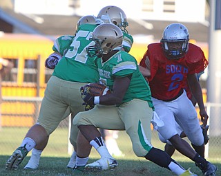 Ursuline's  Joe Floyd Jr. (7) picks up a block from teammate Dan Henry (57) during the first quarter of Friday nights matchup at Rayen Field in Youngstown.