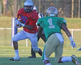 Youngstown East's Michael Lawrence (2) tries to get to the corner around Ursuline's  Daylen Harris (1) during the first quarter of Friday nights matchup at Rayen Field in Youngstown.