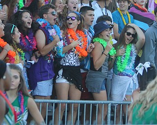 The Ursuline High School student section dresses up in beachware while celebrating during the first quarter of Friday nights matchup at Rayen Field in Youngstown.