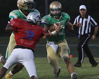 Ursuline's Jared Fabry (13) picks up a block by teammate Tristan Ballard (12) on Youngstown East's Stephon McQueen (9) during the second quarter of Friday nights matchup at Rayen Field in Youngstown. Dustin Livesay  |  The Vindicator  9/2/16  Rayen Stadium