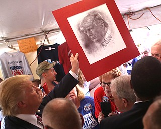 Canfield, Ohio | September 5, 2016: ..Republican presidential candidate Donald Trump autographs a portrait of himself from a local supporter while inside the Mahoning Country Republican Party tent during a stop to the 170th Canfield Fair on Monday, Sept. 5, 2016 in Canfield, Ohio...Nikos Frazier | The Vindicator.