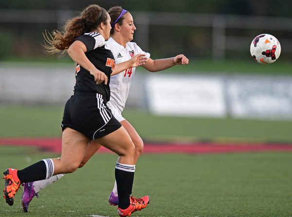 CANFIELD, OHIO - SEPTEMBER 7, 2016: Alana Petracci #14 of Canfield and Leah Pollifrone #22 of Howland chase after the bouncing ball in the first half of their game Wednesday night at Canfield High School. DAVID DERMER | THE VINDICATOR