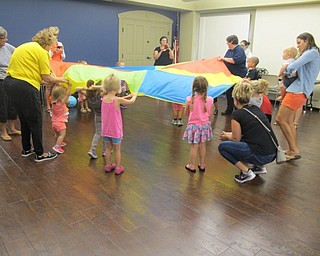 Neighbors | Alexis Bartolomucci.The younger children moved the parachute up and down with the help of the adults during story time on Aug. 17 at the Boardman library.